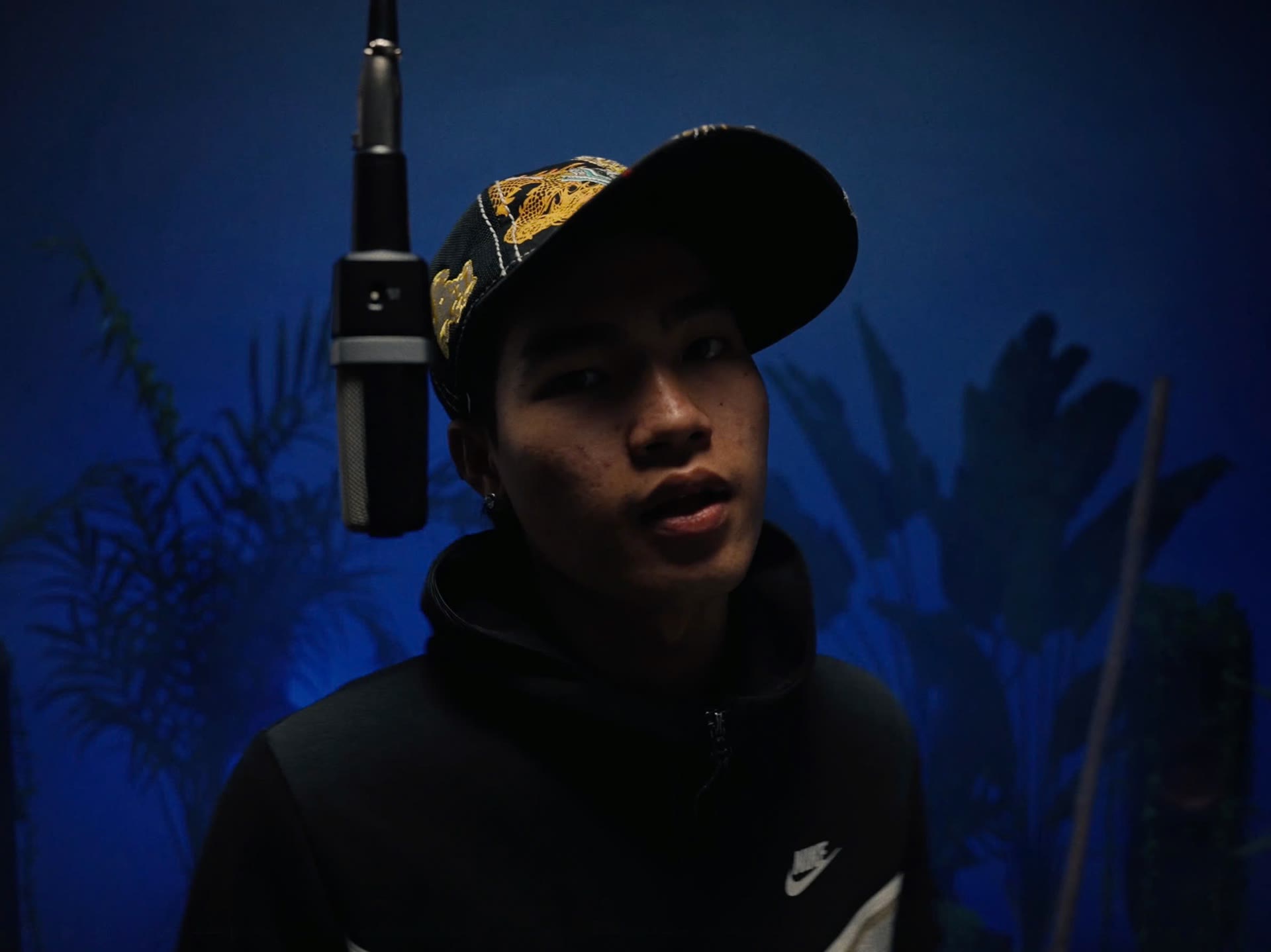 Artist under the hanging mic on the blue session floor